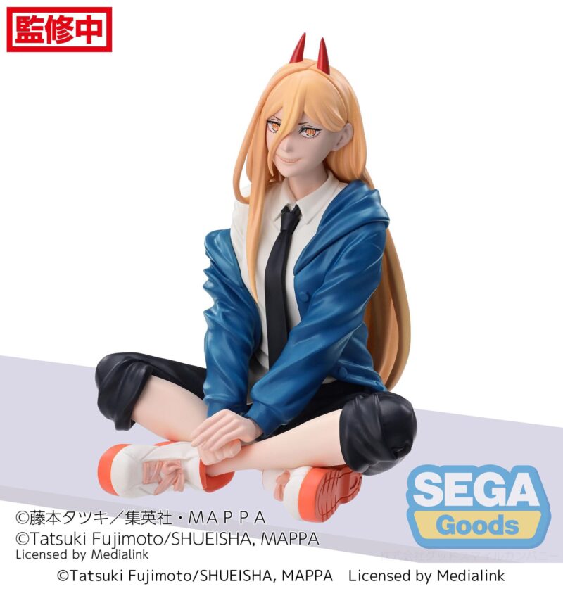 Vue 3/4 de face à mi-distance de la figurine de Power de Chainsaw Man, assise, portant une veste bleue et des cornes rouges.