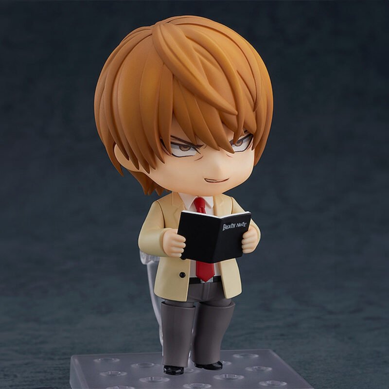 Vue 3/4 de face à mi-distance de la figurine de Light Yagami de Death Note en blazer beige, tenant le Death Note.