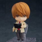 Vue de face en plan rapproché moyen de la figurine Nendoroid de Light Yagami de Death Note en blazer clair, tenant le "Death Note".
