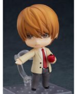 Vue 3/4 de face à mi-distance de la figurine Nendoroid de Light Yagami de Death Note en blazer crème, tenant une pomme rouge.