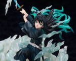 Vue 3/4 de près de la figurine de Muichiro Tokito de Demon Slayer en uniforme noir, préparant son épée bleue.
