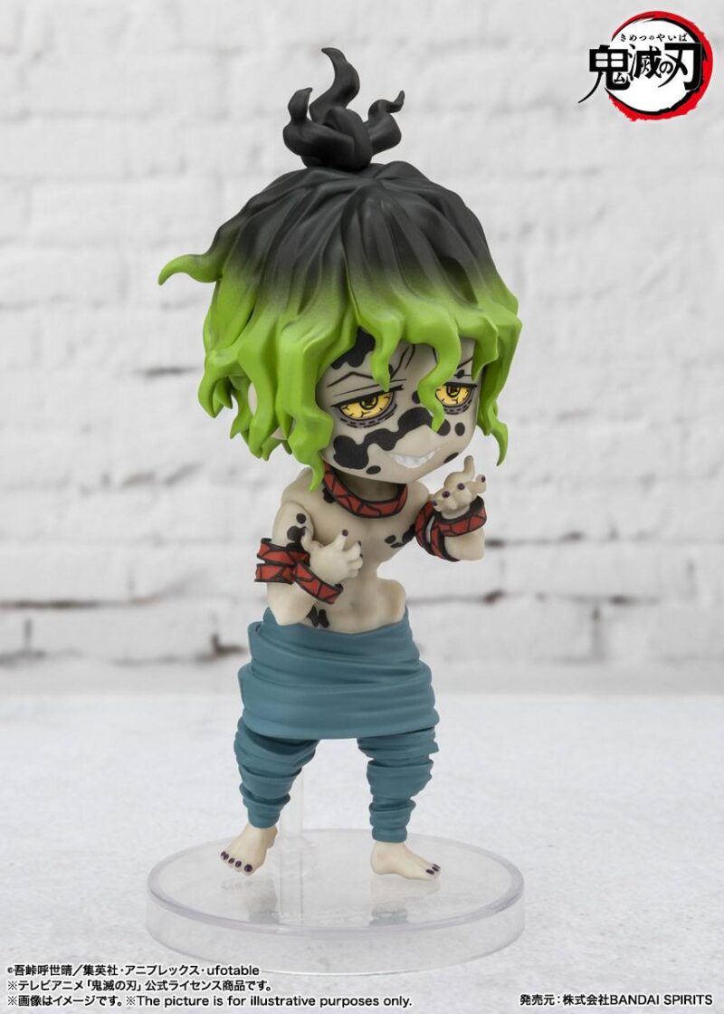 Vue 3/4 en angle légèrement élevé avec plan rapproché moyen de la figurine de Gyutaro de Demon Slayer, en pantalon bleu, avec un sourire malicieux.