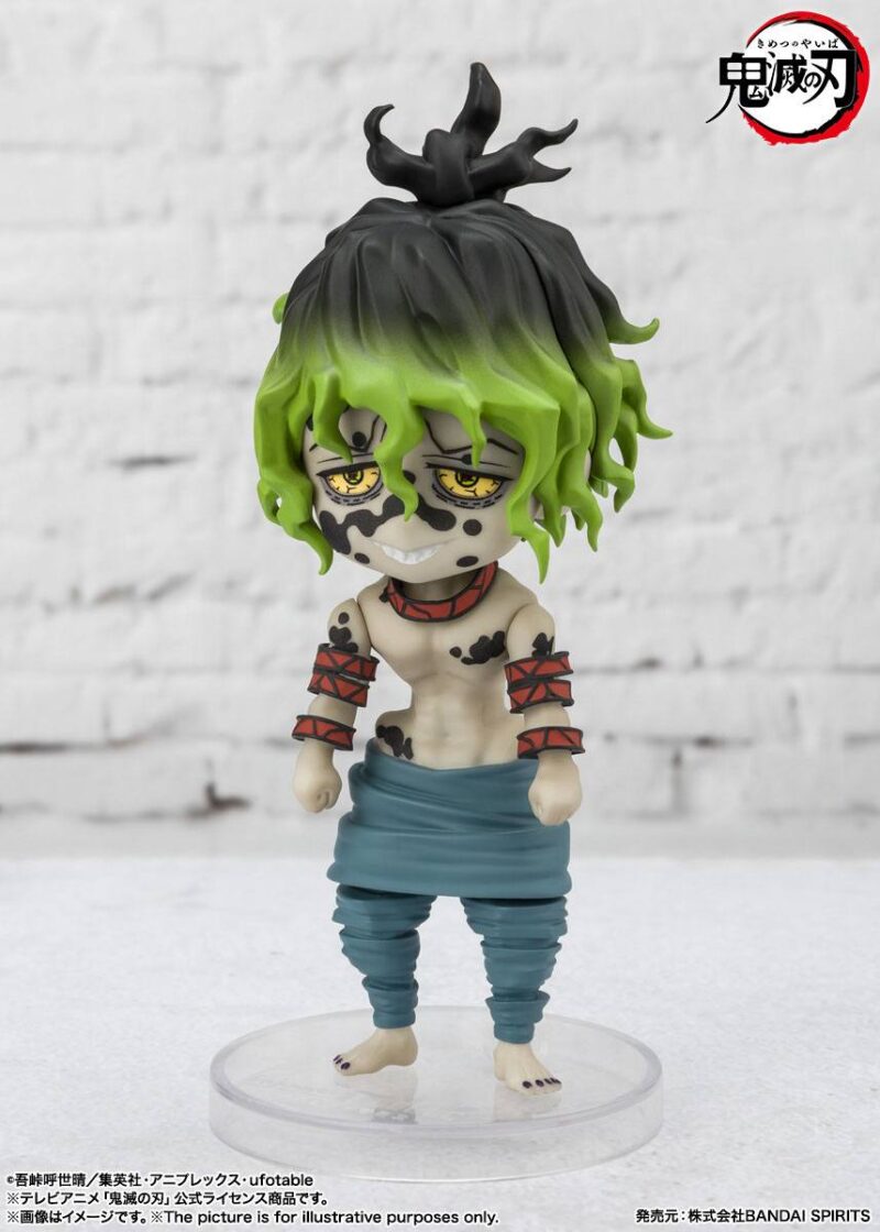 Vue 3/4 à mi-distance de la figurine de Gyutaro de Demon Slayer: Kimetsu no Yaiba, en pantalon turquoise, avec un sourire malicieux.