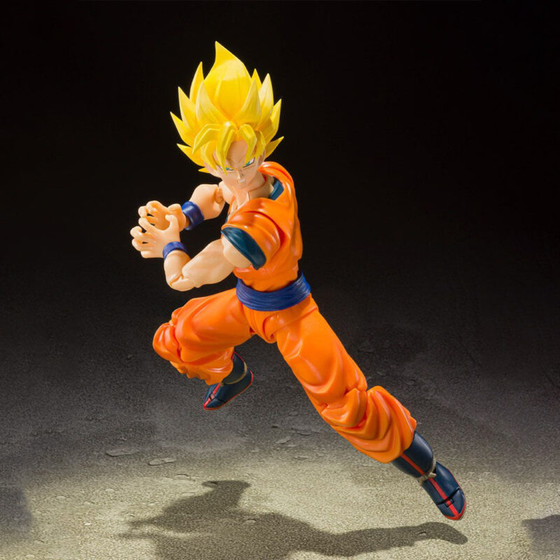 Figurine de Son Goku en Super Saiyan, articulée, mesurant 14 cm, avec trois visages interchangeables et plusieurs paires de mains, représentant le personnage dans sa tenue de combat classique orange et bleue.