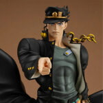 Vue 3/4 de face en plan rapproché moyen de la figurine de Jotaro Kujo de JoJo's Bizarre Adventure, en veste noire avec détails dorés, pointant en avant.