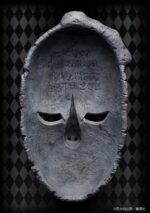 Vue de face en plan rapproché moyen du masque de pierre de JoJo's Bizarre Adventure, avec des détails sculptés.