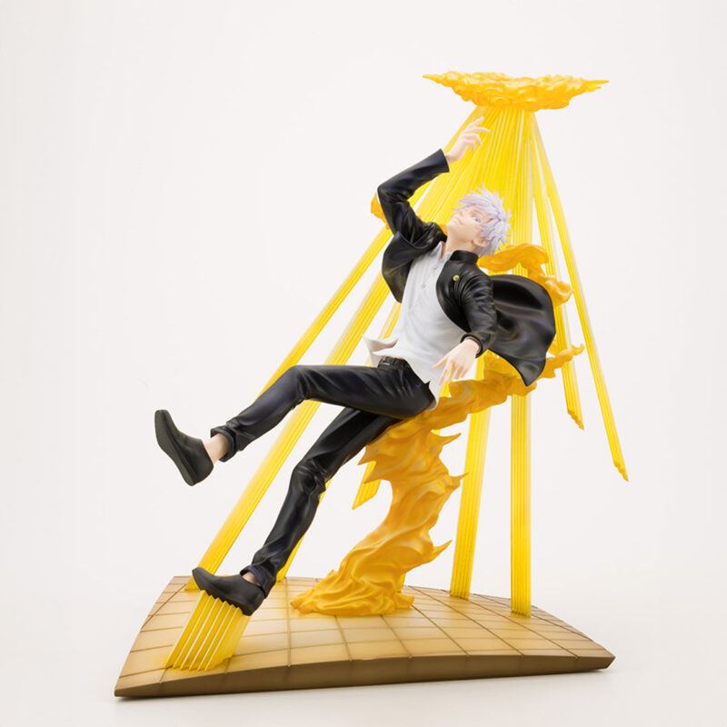 Figurine Deluxe de Gojo Satoru de la série Jujutsu Kaisen en tenue noire, en posture dynamique avec expression confiante, bras droit levé et main gauche tendue. Vue de face à mi-distance.