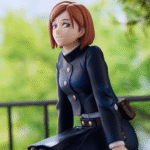 Figurine Funko Pop! de Nobara Kugisaki de la série Jujutsu Kaisen en uniforme bleu marine, assise avec un léger sourire, vue de face à mi-distance.