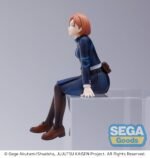 Figurine Sega de Nobara Kugisaki de la série Jujutsu Kaisen en uniforme bleu, assise avec expression confiante, mains sur un cube. Vue de 3/4 à mi-distance.