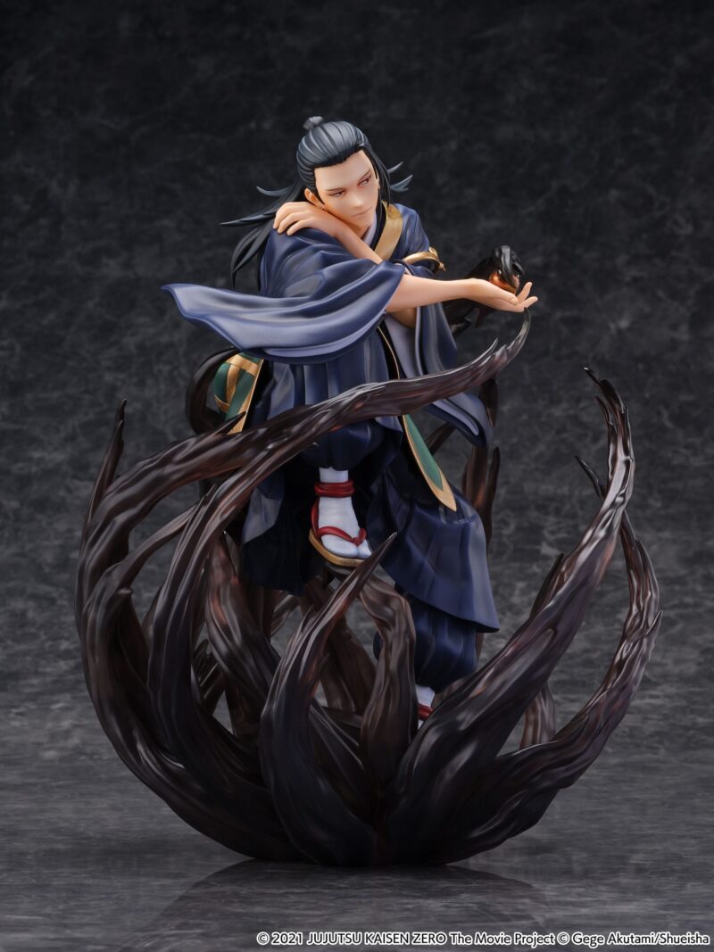 Figurine de Suguru Geto de la série Jujutsu Kaisen Zero en kimono bleu avec accents dorés, en posture dynamique avec expression sérieuse, tenant un objet lumineux. Vue 3/4 à mi-distance.