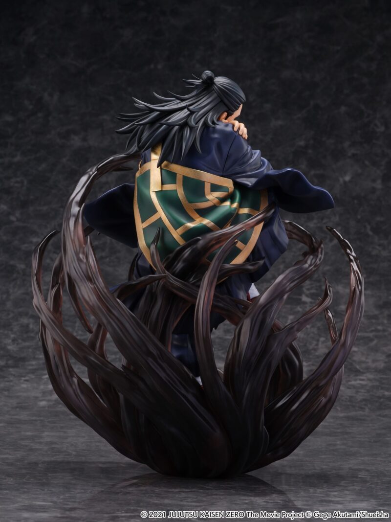 Figurine de Suguru Geto de la série Jujutsu Kaisen Zero en robe bleu foncé avec une cape géométrique verte et dorée, en posture accroupie avec expression sérieuse, entouré d'une énergie sombre. Vue de face à mi-distance.