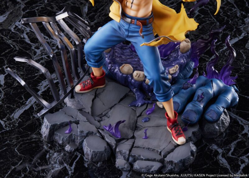 Figurine de Ryomen Sukuna de la série Jujutsu Kaisen en pantalon bleu et manteau jaune, en posture dynamique avec expression menaçante, sur une base rocheuse avec des flammes violettes. Vue de face à mi-distance.