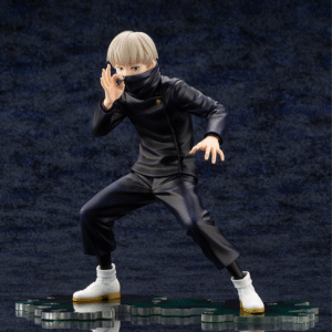 Figurine Toge Inumaki de la série Jujutsu Kaisen en tenue sombre, en posture dynamique avec expression sérieuse, main gauche près du visage et main droite tendue. Vue de face à mi-distance.