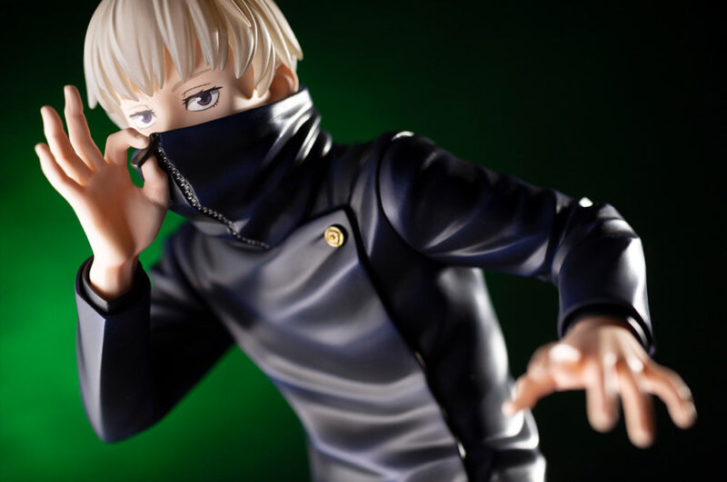 Figurine Toge Inumaki de la série Jujutsu Kaisen en tenue sombre, en posture dynamique avec expression intense, main près du visage et l'autre main tendue. Vue de face à mi-distance.