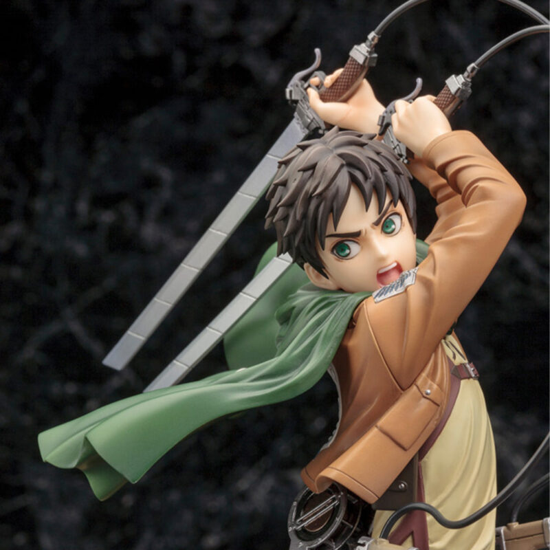 Vue dynamique à mi-distance de la figurine ArtFX J d'Eren Yeager de Shingeki no Kyojin, en veste militaire, tenant des lames.