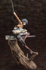 Vue 3/4 de face en plan entier de la figurine de Mikasa Ackerman de Shingeki no Kyojin, en uniforme militaire, avec une épée levée.