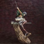 Vue 3/4 à mi-distance de la figurine ArtFX J de Mikasa Ackerman de Shingeki no Kyojin en uniforme militaire, tenant des lames.