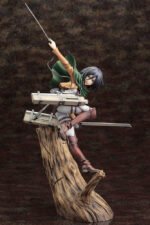 Vue 3/4 à mi-distance de la figurine ArtFX J de Mikasa Ackerman de Shingeki no Kyojin en uniforme militaire, tenant deux lames.