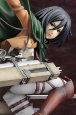Vue en diagonale avec plan rapproché moyen de la figurine ArtFX J de Mikasa Ackerman de Shingeki no Kyojin en uniforme militaire, avec des équipements de manœuvre 3D.