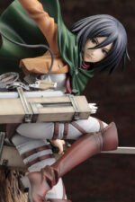 Vue 3/4 de face à mi-distance de la figurine ARTFX J de Mikasa Ackerman de Shingeki no Kyojin en uniforme militaire, avec équipement de manœuvre 3D.