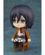Vue de face à mi-distance de la figurine Nendoroid de Mikasa Ackerman de Shingeki no Kyojin en veste militaire, assise sur une chaise.