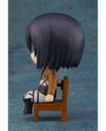 Vue de profil à mi-distance de la figurine Nendoroid de Mikasa Ackerman d'Attack on Titan en uniforme de Scout, assise sur une chaise.