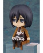Vue 3/4 de face en plan rapproché moyen de la figurine Nendoroid de Mikasa Ackerman de Shingeki no Kyojin en uniforme militaire, assise sur une petite chaise.