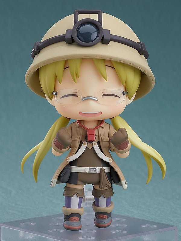 made-in-abyss-figurine-nendoroid-riko_1_5dd53013-af11-4e20-89a4-d00371d02c9d Vue de face en plan d'ensemble de la Nendoroid de Riko de Made in Abyss avec les bras légèrement levés.