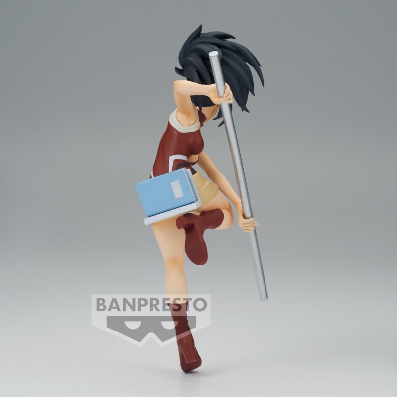 Vue 3/4 de face à mi-distance de la figurine  de Momo Yaoyorozu de My Hero Academia en tenue rouge et jupe beige, tenant un long bâton.