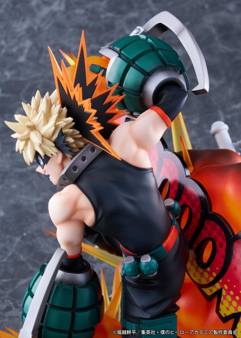 Vue 3/4 arrière à mi-distance de la figurine de Katsuki Bakugo de My Hero Academia en tenue noire sans manches, avec des gantelets explosifs.