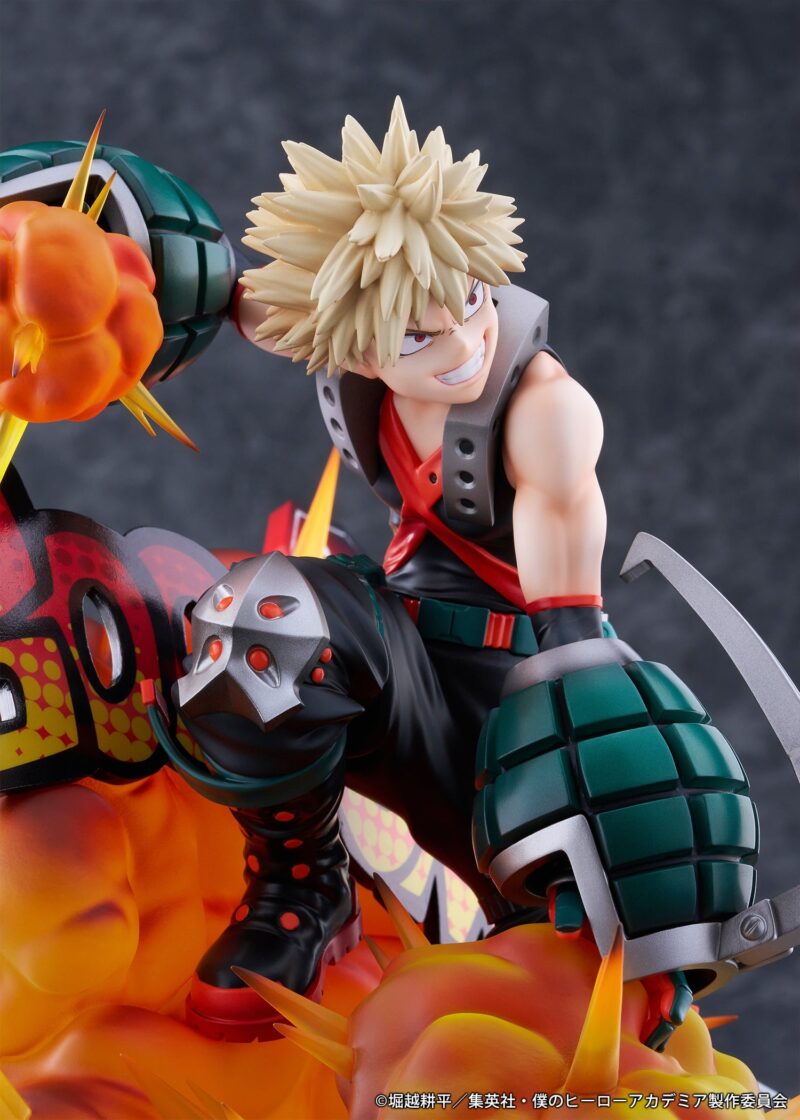 Vue 3/4 de face à mi-distance de la figurine de Katsuki Bakugo de My Hero Academia en veste noire sans manches, avec des gantelets explosifs, effets d'explosion.