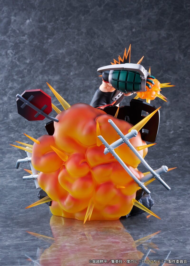 Vue diagonale à mi-distance de la figurine de Katsuki Bakugo de My Hero Academia en costume de héros, lançant une explosion de ses paumes.