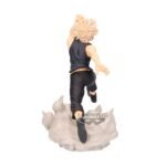 Vue 3/4 arrière à mi-distance de la figurine  de Katsuki Bakugo de My Hero Academia, en haut noir sans manches, bras droit levé, sur une base de débris explosifs.