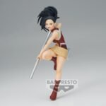 Vue 3/4 de face à mi-distance de la figurine  de Momo Yaoyorozu de My Hero Academia en tenue rouge et beige, tenant un grand bâton métallique.