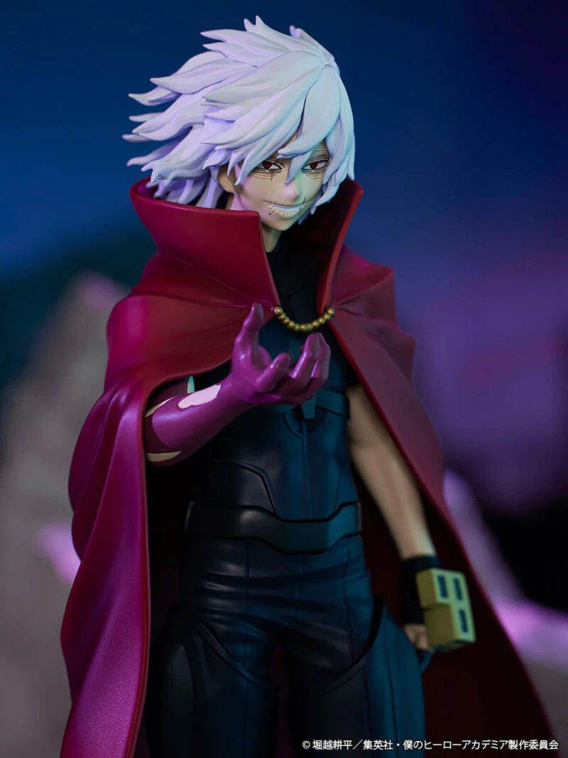 Vue 3/4 de face en gros plan de la figurine d'un personnage inconnu en tenue sombre avec une cape rouge, main tendue.