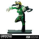 Vue 3/4 de face à mi-distance de la figurineTsuyu Asui de My Hero Academia en costume de héros vert, avec des lunettes sur le front.