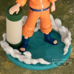 Figurine de Naruto Uzumaki avec lunettes de protection et rouleau des techniques interdites sur un socle bleu ciel.