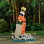Figurine de Naruto Uzumaki avec lunettes de protection et rouleau des techniques interdites sur un socle bleu ciel.