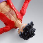 one-piece-figurine-luffy-gear-5-sh-figuarts_3 Figurine articulée de Monkey D Luffy en Gear 5 mesurant 15 cm, avec visage optionnel, quatre expressions faciales, trois paires de mains et bras étendus, représentant une scène dynamique de combat.