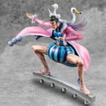 Figurine de Bon Clay avec une pose dynamique, portant une jupe bleue rayée, une ceinture rouge et une longue cape rose ornée d'ailes et de têtes de cygne, fabriquée par MEGAHOUSE.