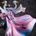 Figurine de Bon Clay avec une pose dynamique, portant une jupe bleue rayée, une ceinture rouge et une longue cape rose ornée d'ailes et de têtes de cygne, fabriquée par MEGAHOUSE.