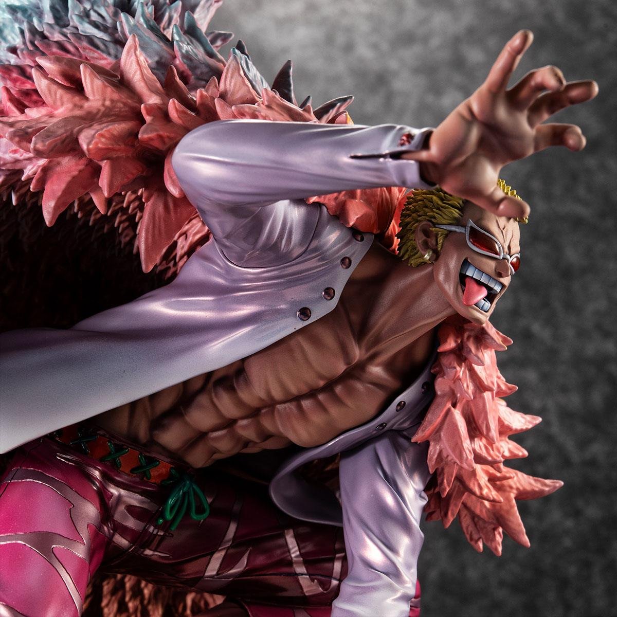 Figurine de Doflamingo portant un manteau en plumes roses et des lunettes de soleil en forme de tête de flamant rose, avec une pose dynamique et des détails colorés, fabriquée par MegaHouse.