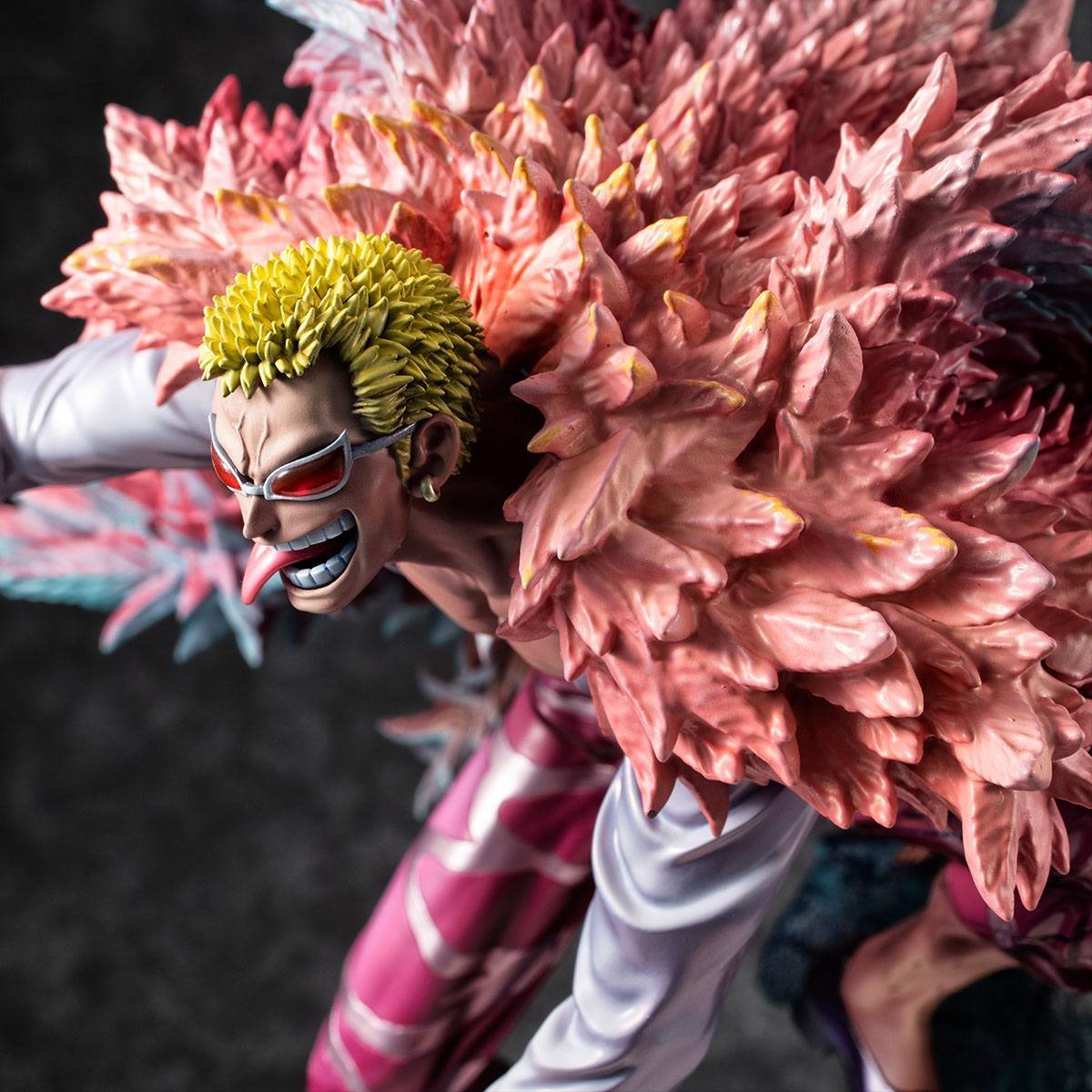Figurine de Doflamingo portant un manteau en plumes roses et des lunettes de soleil en forme de tête de flamant rose, avec une pose dynamique et des détails colorés, fabriquée par MegaHouse.